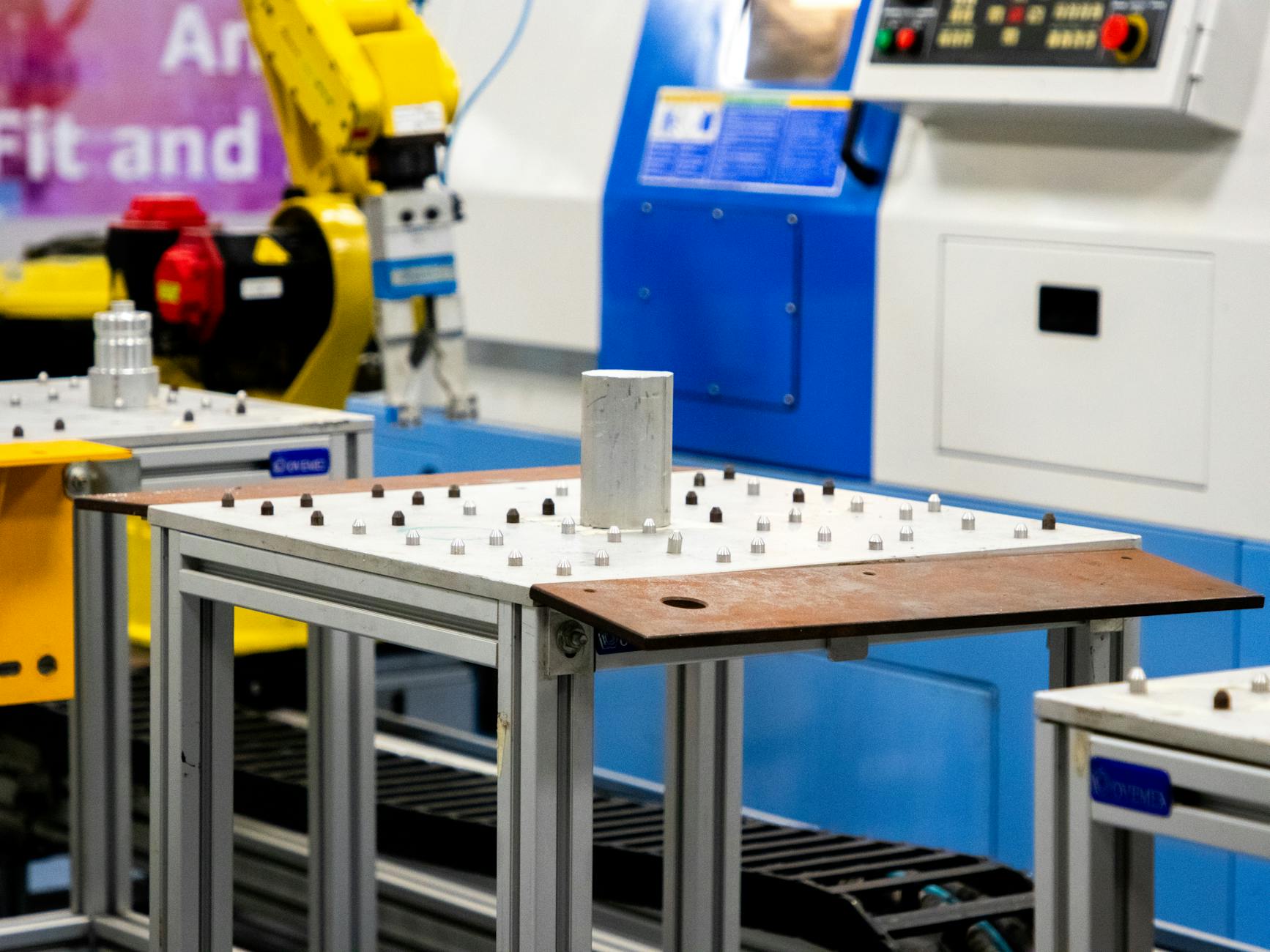 Nowości w oprogramowaniu do planowania produkcji APS: krótsze serie, większa elastyczność, więcej danych Zbliżenie zautomatyzowanej maszyny produkcyjnej w hali przemysłowej